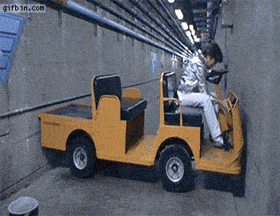 a person is driving a yellow vehicle in a tunnel with gifbin.com written on the bottom right