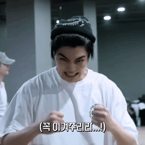 a man wearing a white shirt and a black hat with korean writing