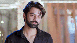 a man with a beard wearing a black shirt is looking at the camera .