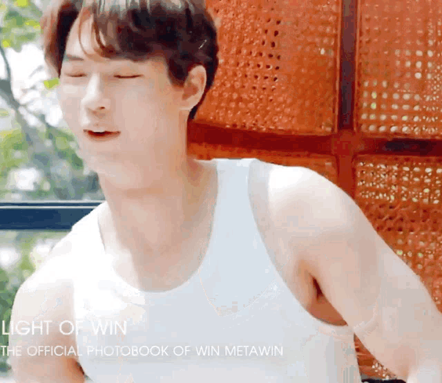 a man is wearing a white tank top with the words light of win on the bottom