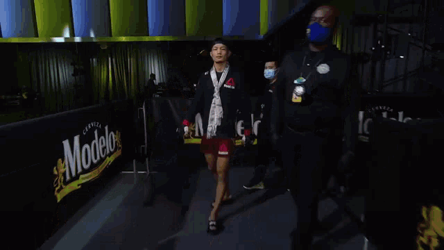 a man wearing a mask and gloves is walking through a hallway .