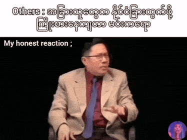 a man in a suit and tie is sitting in front of a black background with the words " my honest reaction " below him