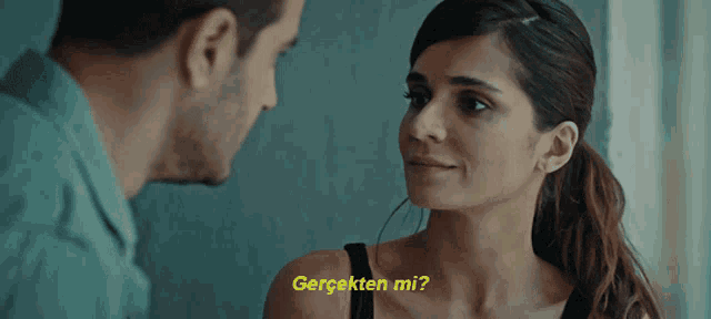 a man and a woman are looking at each other and the woman is asking the man " gerçekten mi ? "