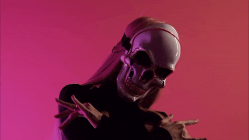 a woman is wearing a glowing skull mask and making a funny face .