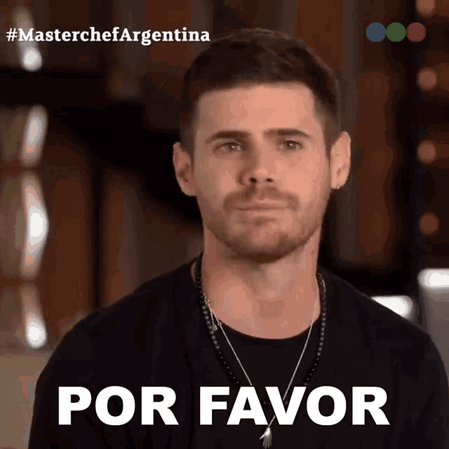 a man wearing a black shirt and a necklace with the words por favor on the bottom