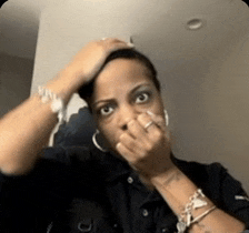 a woman covering her mouth with her hand while wearing a watch