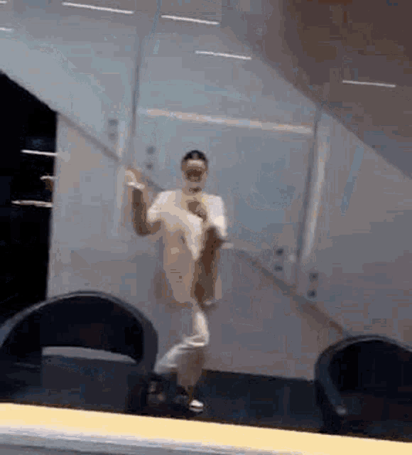 a man is dancing in a room in front of a mirror .