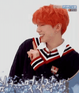 a man with red hair is smiling and giving a thumbs up .