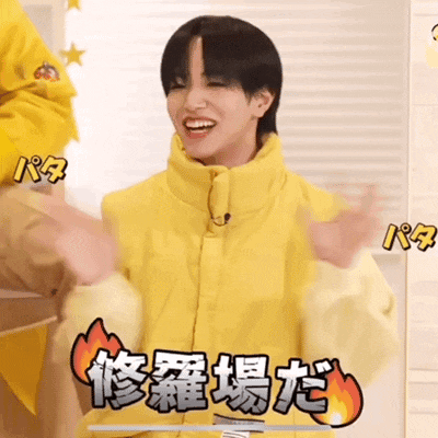 a man in a yellow jacket is smiling and holding his arms out in front of him .