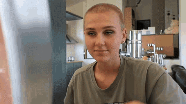 a woman with a shaved head is wearing a t-shirt that says ' abercrombie & fitch '