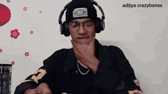 a man wearing headphones and a beanie has the name aditya crazybones on the bottom