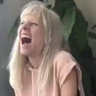 a woman with long blonde hair is laughing with her mouth wide open