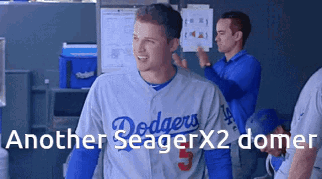 a man wearing a dodgers jersey is standing in a dugout