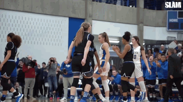 a group of female basketball players standing on a court with the word slam on the bottom right