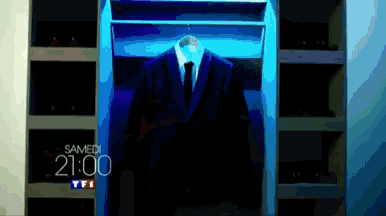 a suit is hanging in a closet that says samedi 21:00 on it
