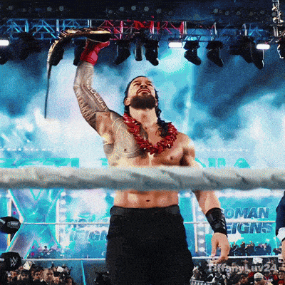 a man in a wrestling ring with roman reigns on the wall behind him