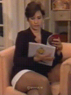 a woman is sitting in a chair reading a book