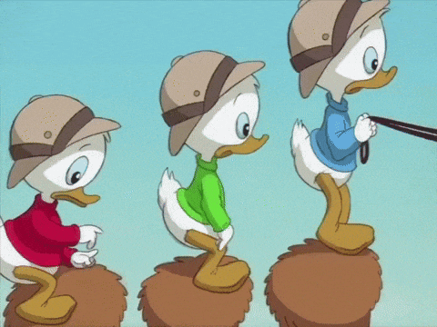three cartoon ducks wearing hats and sweaters are standing on a pile