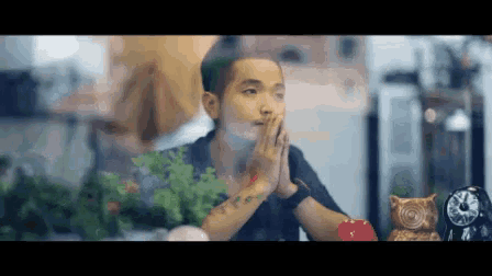 a man with a tattoo on his arm is sitting at a table