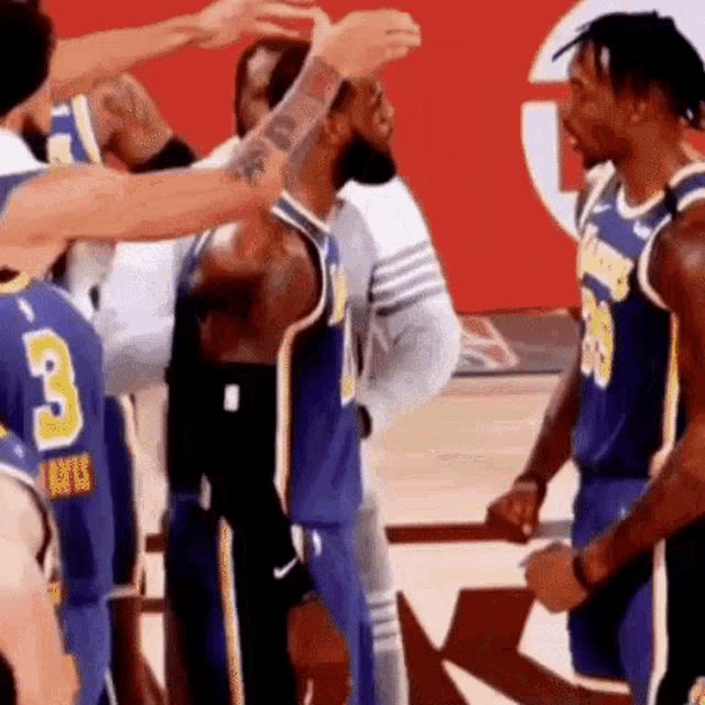 a group of basketball players are standing next to each other on the court .