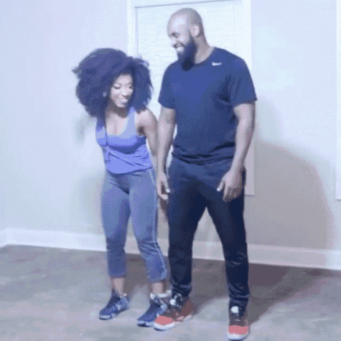 a man in a nike shirt is standing next to a woman