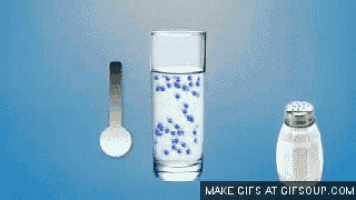 a glass of water a spoon and a salt shaker are shown on a blue background