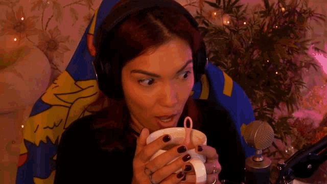 a woman wearing headphones and holding a cup with a pink straw