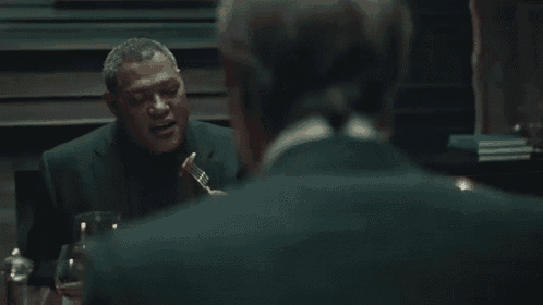 a man in a suit is talking to another man