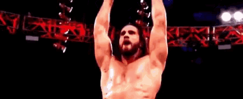 a wrestler is standing in front of a sign that says wrestling