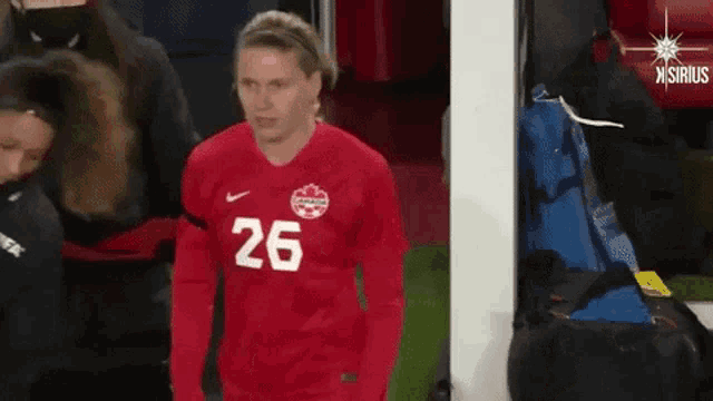 a female soccer player wearing a red jersey with the number 26 on it
