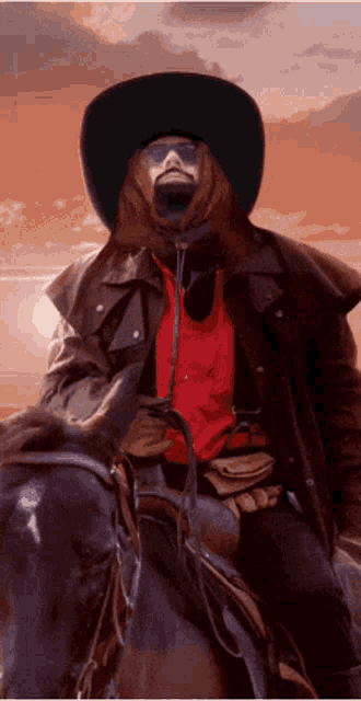 a man wearing a cowboy hat is riding a horse