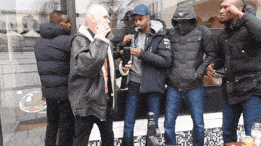 a group of men are standing in front of a building with a sign that says ' a ' on it