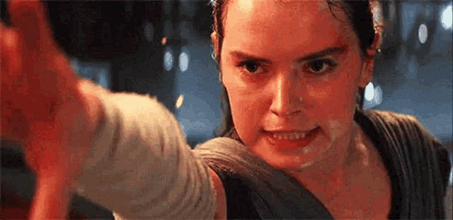 a close up of a woman 's face with a man 's arm behind her .