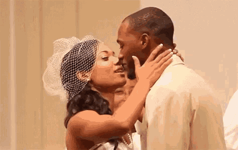 a bride and groom are kissing at their wedding ceremony in a church .
