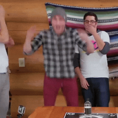 a man in a plaid shirt is covering his mouth while dancing