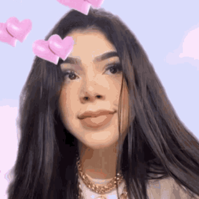 a close up of a woman 's face with pink hearts on her face .