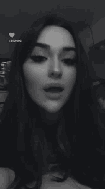 a black and white photo of a woman sticking out her tongue