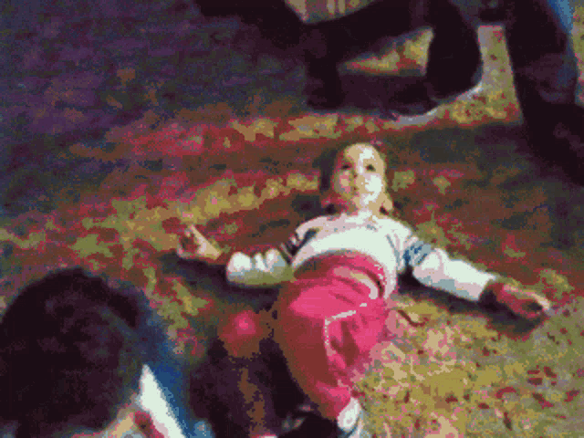 a pixelated image of a little girl laying on the ground