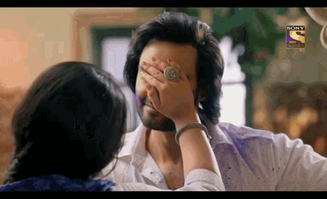 a man covering his face with a woman 's hand with a sony television logo visible