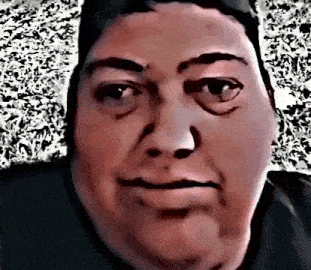 a close up of a man 's face with a blurry background and a black shirt .