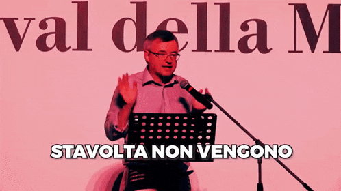a man is speaking into a microphone with the words risparmiati written below him