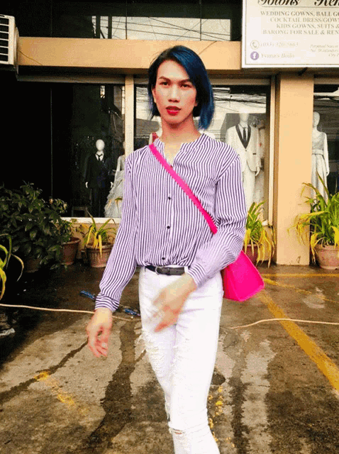 a woman with blue hair is walking in front of a store that sells dresses and cocktail dresses