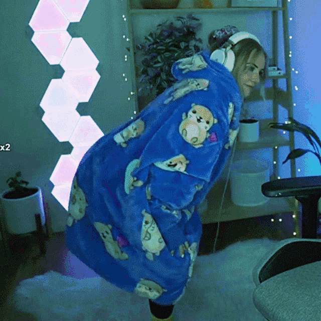 a person wearing a blue robe with bears on it is standing in front of a sign that says x2