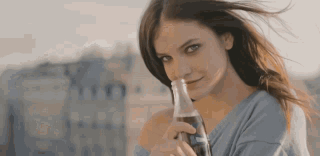 a woman is holding a bottle of coca cola