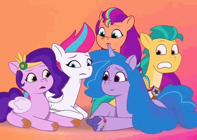 a group of ponies are sitting next to each other and looking at something .