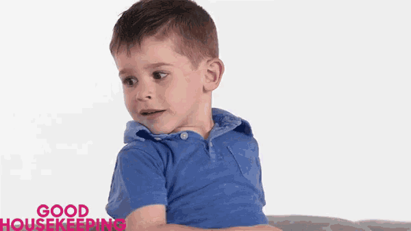 a young boy in a blue shirt is sitting on a couch with good housekeeping written on the bottom right