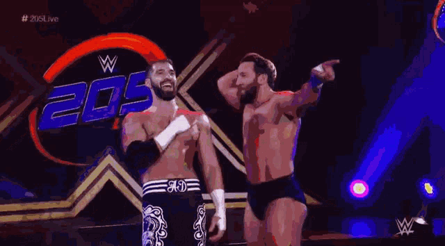 two wrestlers are standing in front of a sign that says 20