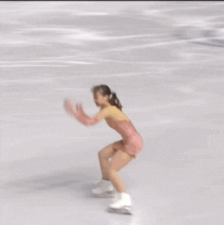 a woman is ice skating in front of a banner that says isu grand prix