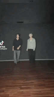 a couple of men are dancing on a wooden floor .