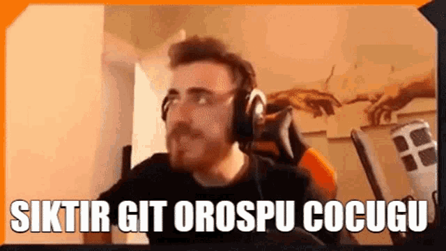 a man wearing headphones is sitting in a chair and making a face .